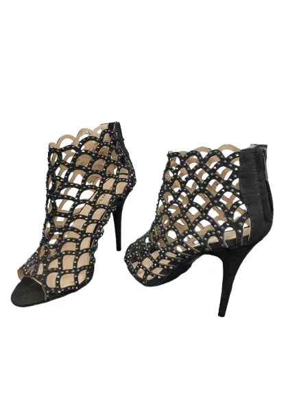 Black strappy high-heeled shoes on a white background