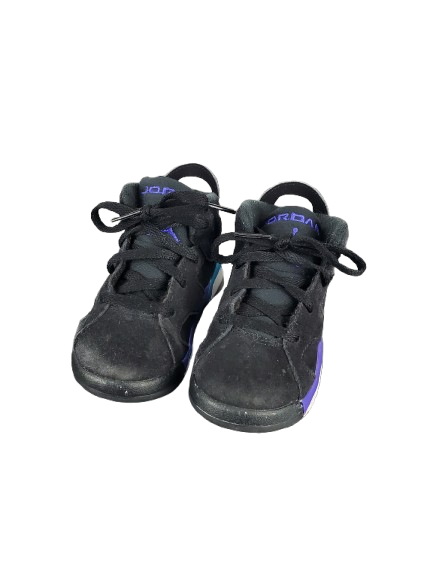 Pair of black sneakers with purple accents on a white background