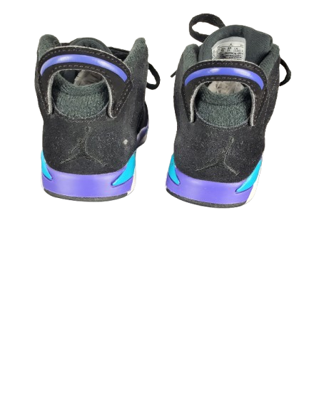 Pair of black sneakers with purple and blue sole on a white background