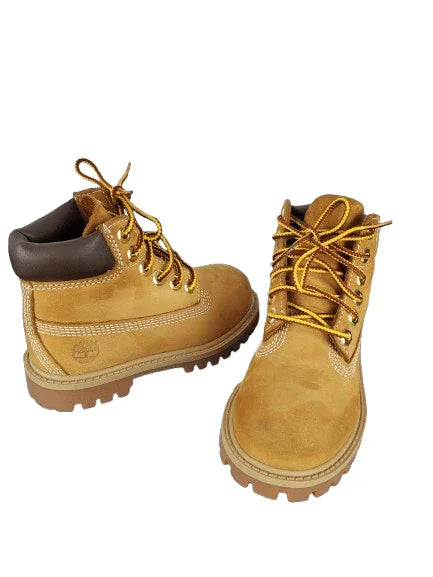 Pair of tan boots with brown accents on a white background