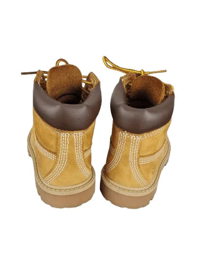 Pair of tan boots with brown tops on a white background