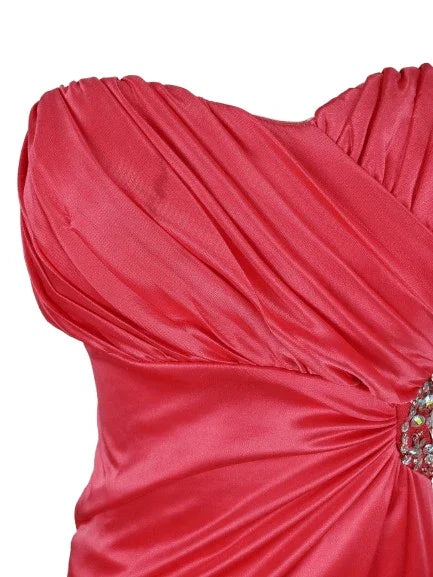 Close-up of a pink dress with a decorative bow on a white background