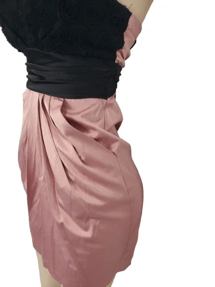 Person wearing a black and pink dress on a white background