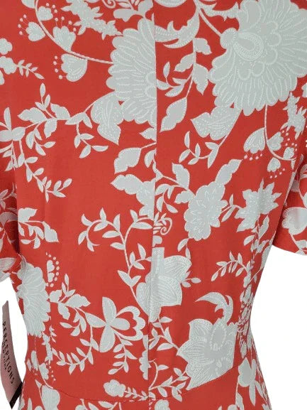 Coral dress with white floral pattern on a plain background