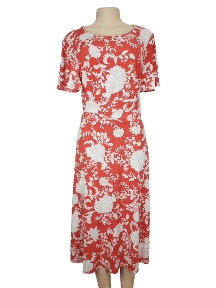 Coral and white floral dress on a mannequin against a white background