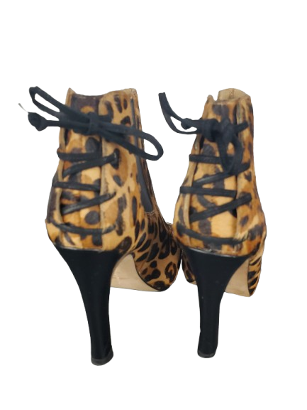 Leopard print high-heeled shoes with black laces on a white background
