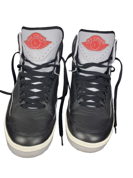 Black high-top sneakers with red logo on a white background