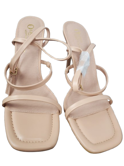 Pair of beige sandals with thin straps on a white background