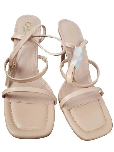 Pair of beige sandals with thin straps on a white background