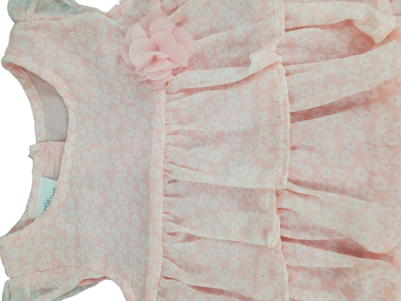 Pink baby romper with ruffles and a flower on a white background