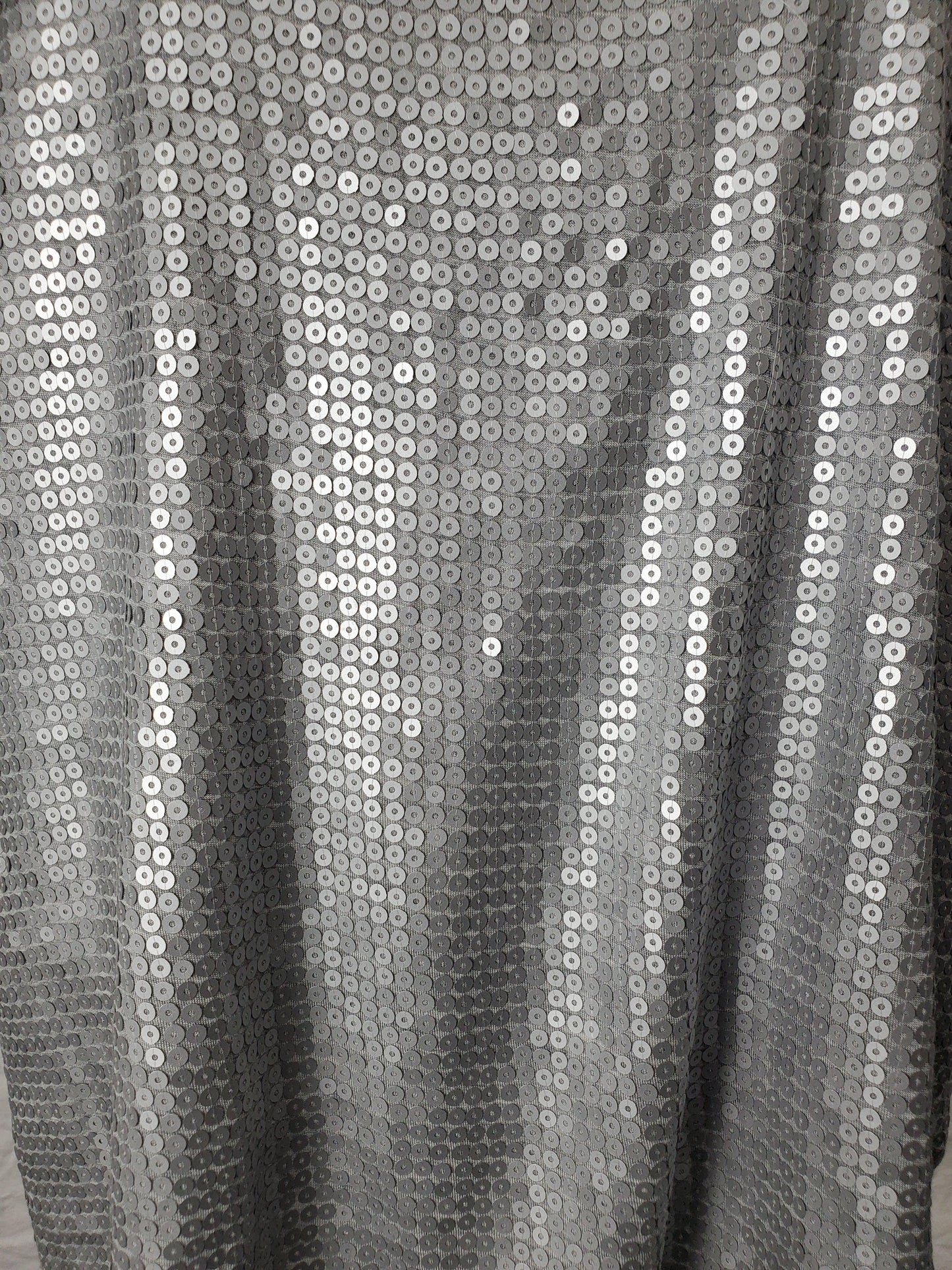Close-up of silver sequin fabric with a black background