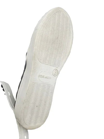 Close-up of a white sneaker sole with 'Steve Madden' branding on a white background