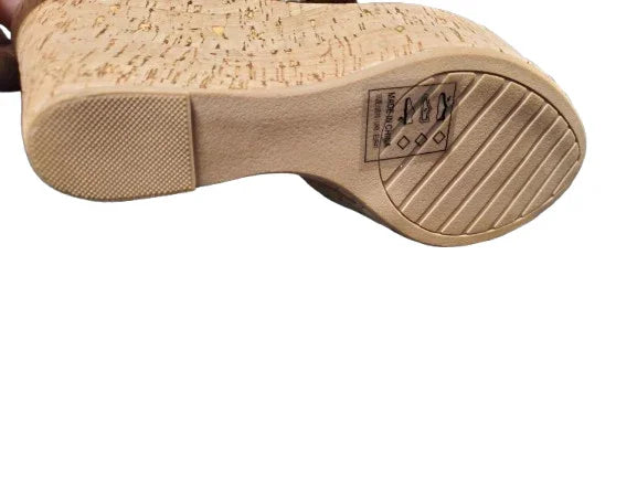 Close-up of a cork shoe sole with brand logo on a white background
