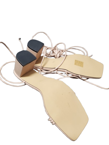 Pair of beige shoe inserts with black ends on a white background