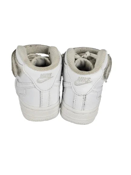 Pair of white high-top sneakers with Nike logo on a white background