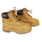 Pair of tan boots with brown accents on a white background