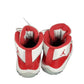 Red and white sneakers with a logo on a white background