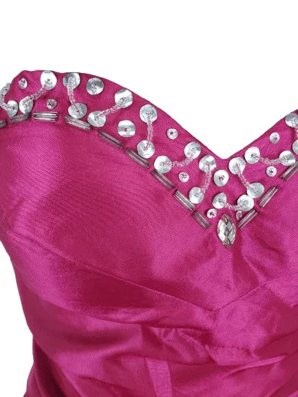Close-up of a pink dress with silver embellishments on a white background