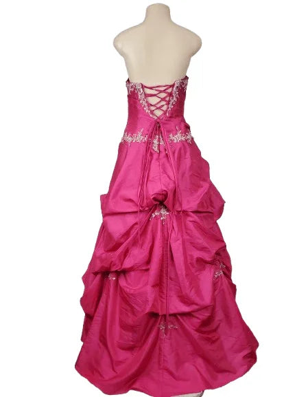 Pink gown with intricate detailing on a mannequin against a white background