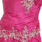 Close-up of a pink dress with intricate silver and crystal embellishments on a white background