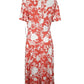 Coral dress with white floral pattern on a mannequin against a white background