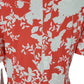 Coral dress with white floral pattern on a plain background