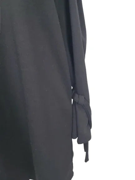 black long-sleeve top with a tie detail on a white background
