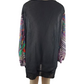 Black dress with colorful sleeves on a mannequin against a white background