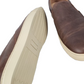 Brown leather shoes with beige soles on a white background
