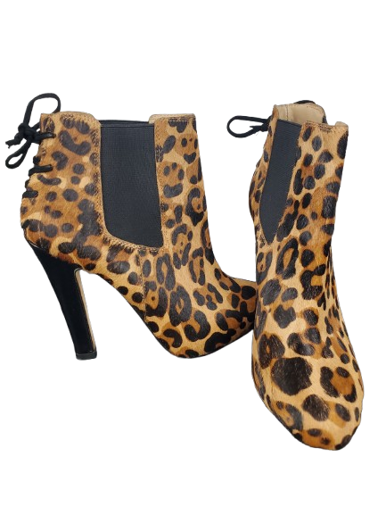 Leopard print ankle boots with black soles on a white background