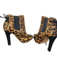 Pair of leopard print high-heeled boots on a white background