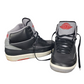 Pair of black high-top sneakers with gray and red accents on a white background