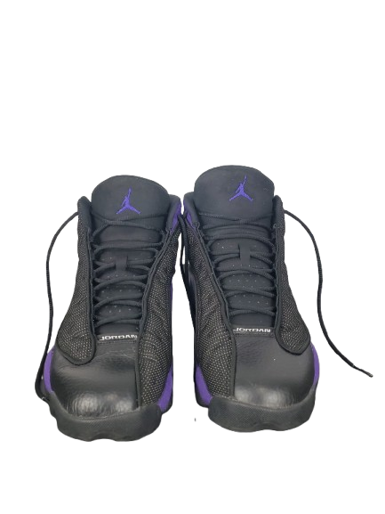 Black Jordan sneakers with purple accents on a white background
