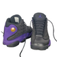 Pair of black and purple sneakers with a visible brand logo on a white background