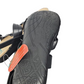 Black sandal with a textured sole on a white background