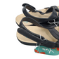 Black sandals with a visible brand tag on a white background