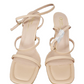 Beige high-heeled sandals with thin straps on a white background