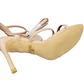 Beige high-heeled shoes with a brand logo on a white background