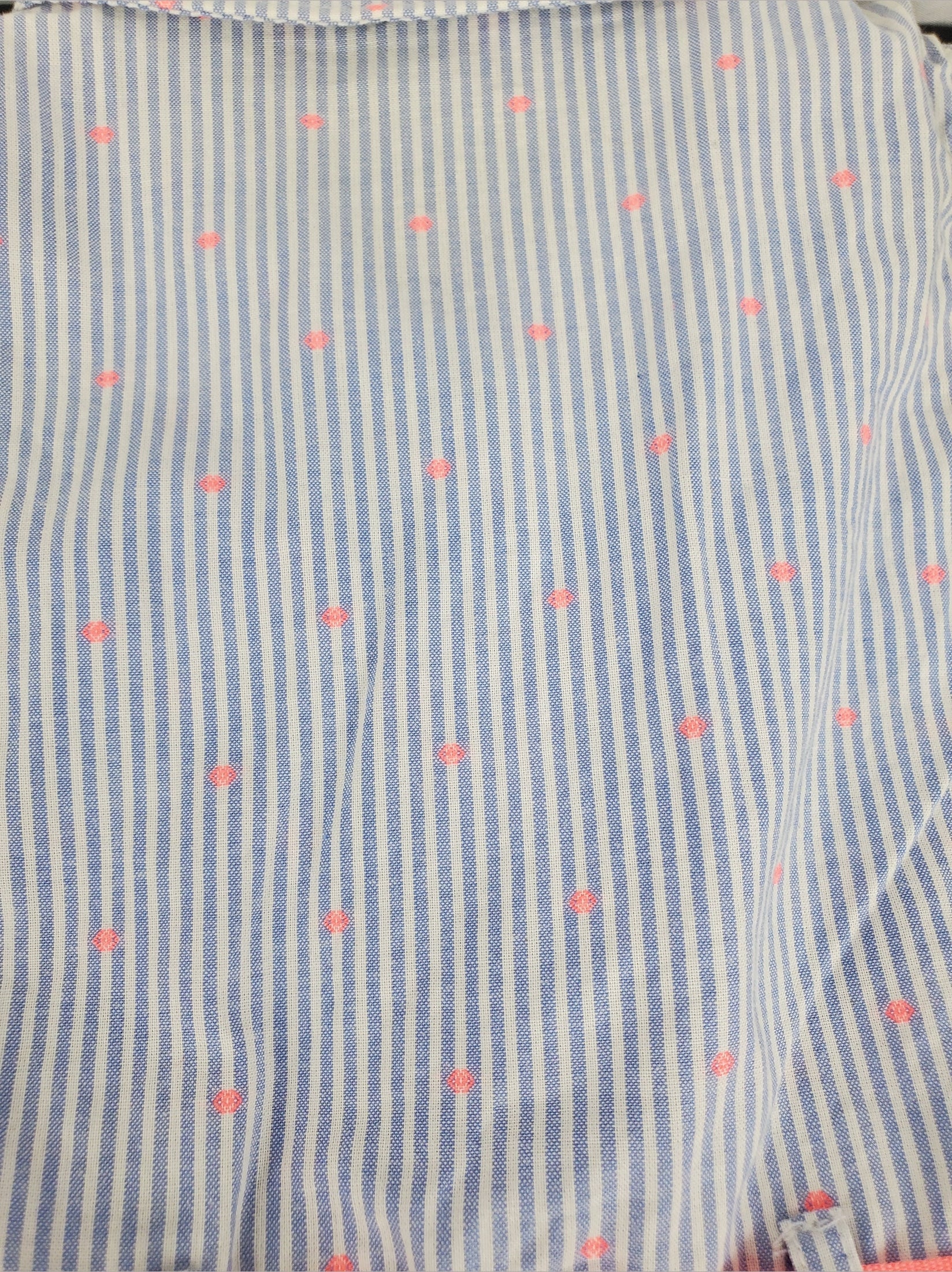 Close-up of a fabric with blue stripes and pink polka dots