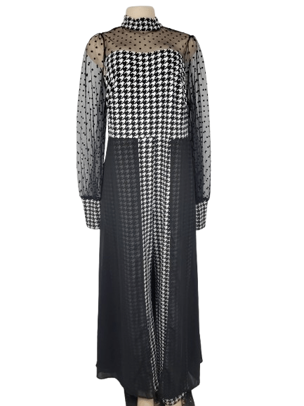 Black and white checkered jumpsuit with sheer sleeves on a mannequin against a white background