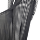 Black and white checkered jumpsuit with sheer sleeves on a mannequin against a white background