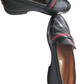 Black leather loafer with a colorful stripe on a white background