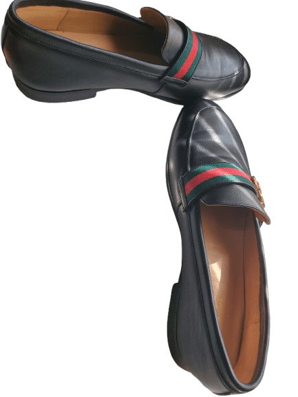 Black leather loafer with a colorful stripe on a white background