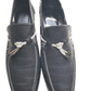 Pair of dark blue loafers with decorative bows on a white background