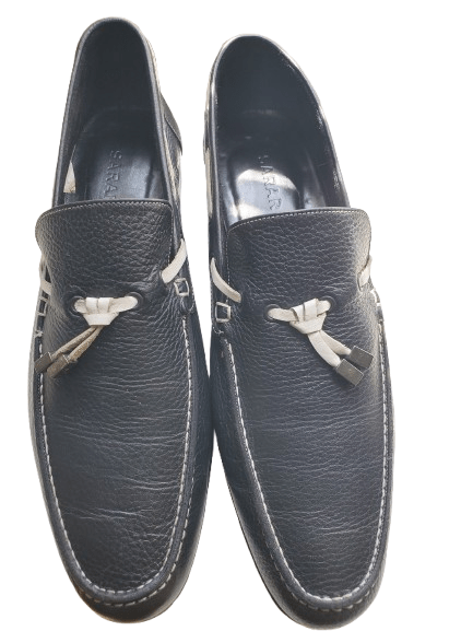 Pair of dark blue loafers with decorative bows on a white background