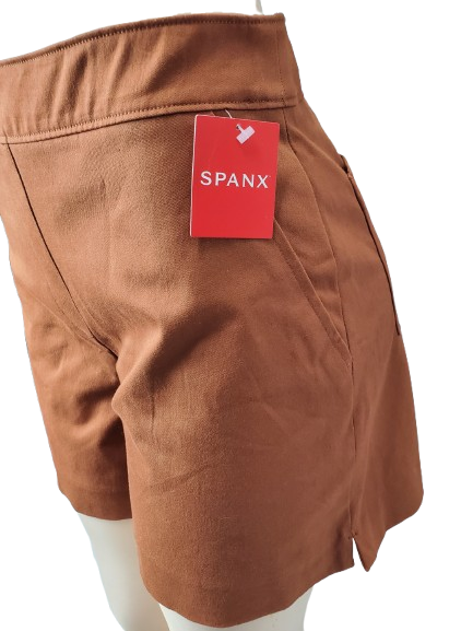 Brown shorts with a red 'Spanx' tag on a white background