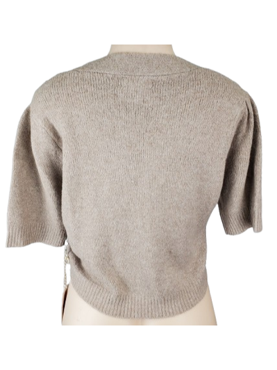 Beige knitted crop top on a mannequin against a white background