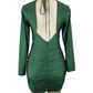 Green dress with open back on a mannequin against a white background