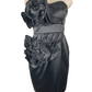 Black tube satin cocktail dress with large ruffle accents displayed on mannequin.