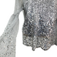 Close-up of a silver sequin dress with long sleeves on a white background